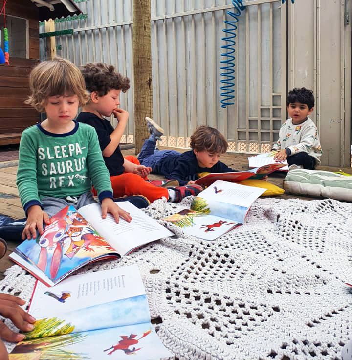Educadora lendo para as crianças
